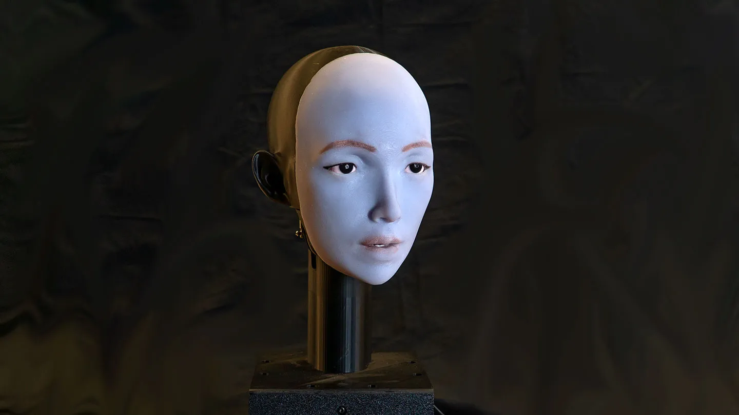 A human-like robot face on a pedestal.
